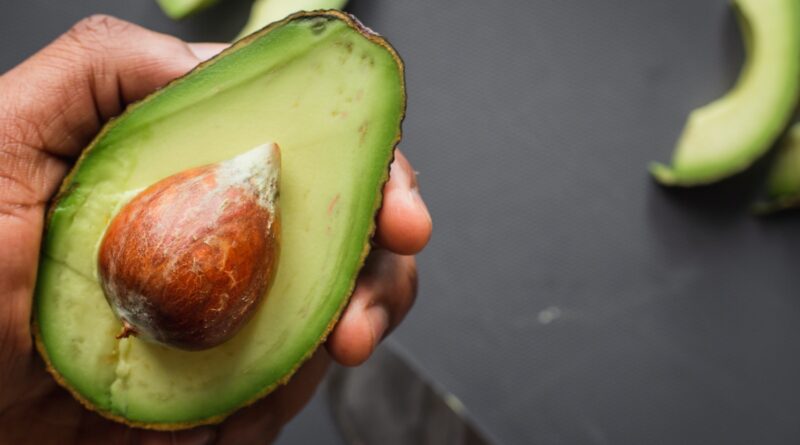 person holding green and brown sliced fruit