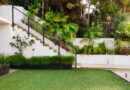 a white house with a green lawn and stairs