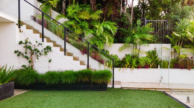 a white house with a green lawn and stairs